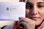 Haseena Niazi, a 24-year-old from Afghanistan, holds a parole denial notice she received from the Department of Homeland Security, while posing outside her home, Friday, Dec. 17, 2021, north of Boston. Niazi received the letter from the federal government denying her fiancé's humanitarian parole application earlier in the month. Her fiance, who she asked not to be named over concerns about his safety, had received threats from Taliban members for working on women's health issues at a hospital north of Kabul.