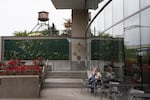People frequent a cafe adjacent to The Fields Park and the Centennial Mills building.