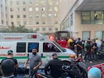 People gather outside the American University hospital after the arrival of several men who were wounded by exploded handheld pagers, in Beirut, Lebanon, Tuesday, Sept. 17, 2024.