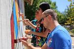 Residents and supporters paint a mural on the wall of the church food bank tagged with hate graffiti. Anyone was invited to paint part of the mural.