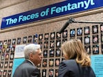 Attorney General Merrick Garland accompanied by U.S. Drug Enforcement Administration Administrator Anne Milgram, looks at photographs of people who had died from drugs during the Second Annual Family Summit on Fentanyl at DEA Headquarters in Washington, Tuesday, Sept. 26, 2023. (AP Photo/Jose Luis Magana)