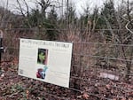 A sign attached to fencing that surrounds winter shrubs.