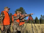 Julianne Hinkle, 16 of Yakima, learns to set up a shot. Mentors Bill Hinkle (left) and Ryan Janke tell her not to shoot because the deer had a young fawn with it.