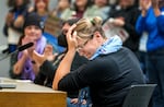 FILE - Former teacher Erin Savage is tearful after the crowd stood and applauded her testimony before the Portland Public Schools Board of Education, at the PPS district office in Portland, Nov. 7, 2023. Savage taught from 2003-2019 and left the profession for lack of pay, classroom support and frustration. 