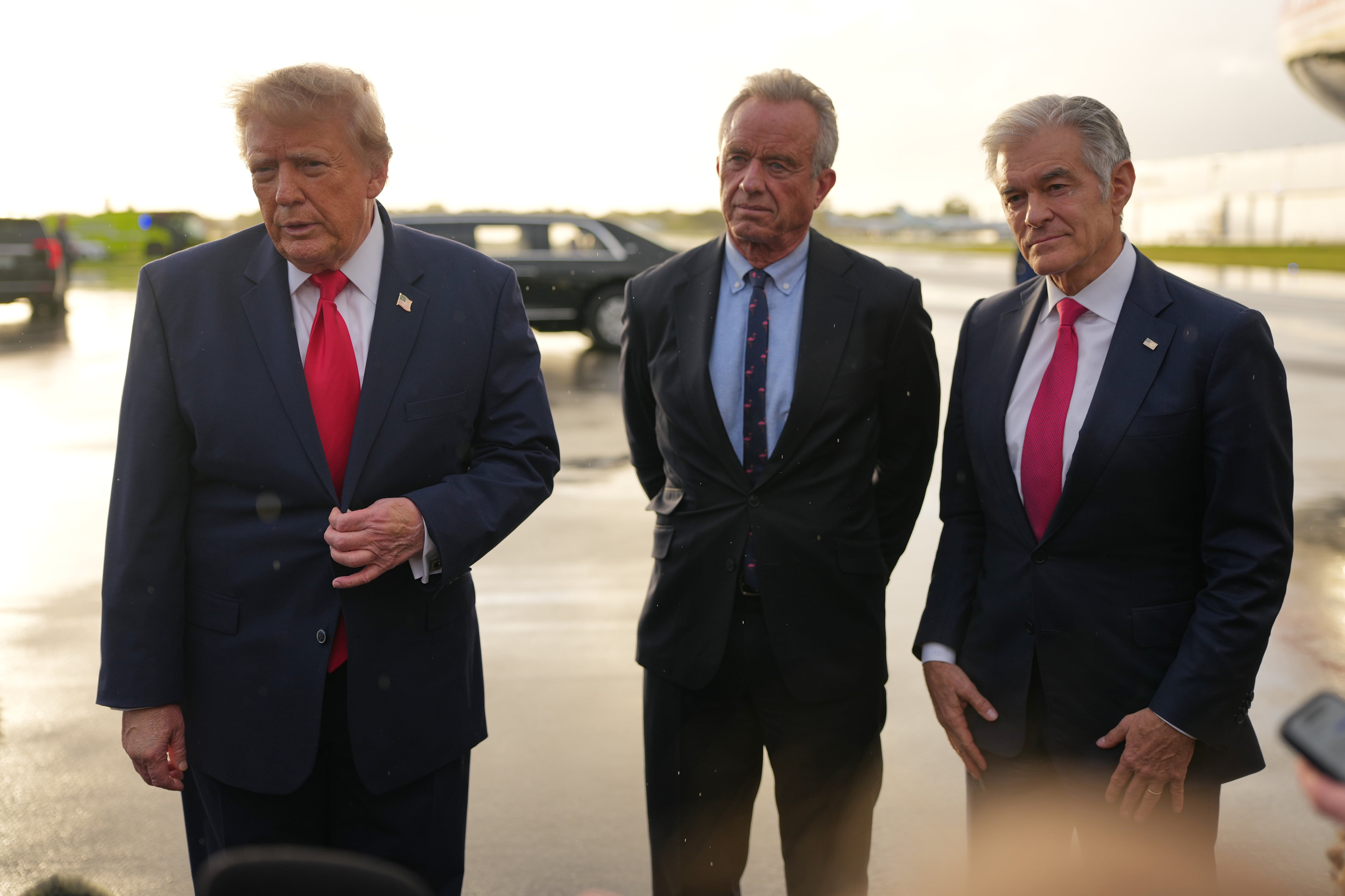 FILE — President Donald Trump talks with reporters after arriving on Air Force One, Friday, Oct. 23, 2026, at President Donald J. Trump International Airport in West Palm Beach, Fla., as Health and Human Services Secretary Robert F. Kennedy Jr. and Centers for Medicare & Medicaid Services administrator Dr. Mehmet Oz listen.
