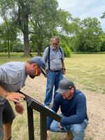 John Robertson watches as workers install new signs on property that is now managed by tribal members.