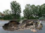 The ground under train tracks in Leominster, Mass., was washed out by flooding, as seen Wednesday. The town northwest of Boston is one of many communities suffering from heavy storms this summer.