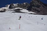 Ski camps practice on the Palmer Snowfield on July 13, 2026, days before Timberline Lodge closed its chairlift due to low snow levels. This had historically been a natural year-round snowfield. Nowadays, the lodge harvests snow from elsewhere on the mountain.