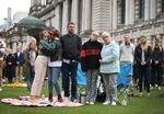 Crowds of people gather to watch the funeral of Queen Elizabeth II on a screen in the grounds of Belfast city hall on Monday.