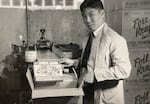 Percy Loy holds a Kubla Khan’s frozen combination dinner near the conveyor belt at the company’s food processing plant in Portland, Ore., in March 1956.