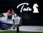 A police officer walks by luxury vehicles which were seized in a case against media influencer Andrew Tate, on the outskirts of Bucharest, Romania, Saturday, Jan. 14, 2023.