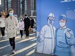 A woman walks past a billboard promoting vaccination outside a shopping mall in Beijing on February 26, 2022. (Photo by Jade Gao / AFP) (Photo by JADE GAO/AFP via Getty Images)