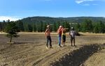 Landowner Craig Woodward (center) gives festival workers directions on earth moving form the top of the earthen amphitheater he shaped from a previously scraped part of land.