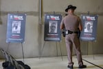 A Florida Highway Patrol officer looks at pictures of undocumented immigrants accused of crimes before a press conference at the ICE Enforcement and Removal Operations building on November 13, 2025 in Miramar, Florida. Florida law enforcement agencies have among the highest ICE cooperation rates in the nation, with state troopers making a significant number of immigration arrests.