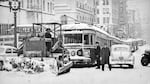 Bulldozer, driven by Henry Wilmes, clears snow off street car tracks on Broadway so they can make their 1st run of the day, NW Portland, 1943.