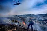 San Diego firefighters knock down a small brush along a hillside over the Mission Valley Shopping Mall in San Diego on Tuesday.