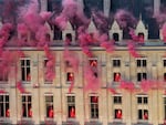 Smoke billows near windows as performers participate during the opening ceremony of the 2024 Summer Olympics, Friday, July 26.