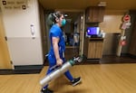 Nurse Danielle LaRocco carries an oxygen tank to the room of a COVID-19 patient on the acute care floor at Salem Health in Salem, Ore., Jan. 27, 2022. Some hospitals are feeling the strain due to the recent surge of coronavirus, such as Salem Health, which had had 540 patients, but only 494 beds available.