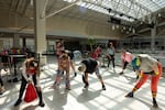 The Food Court 5000 mall walkers stretch before starting their rounds at the Lloyd Center food court on Sunday, April 26, 2026 in Portland, Oregon.