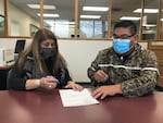 Nez Perce Tribal Executive Committee Chairman Shannon Wheeler (right) and Secretary Rachel Edwards sign paperwork completing the purchase of 148 acres of the tribe's ancestral land in Eastern Oregon.