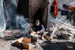 A boy prepares bread to eat outside a tent sheltering displaced Palestinians in Rafah in the southern Gaza Strip on February 8.