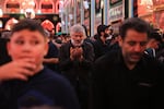 A pilgrim raises his hands in prayer amid the crowds inside the Imam Hussein Shrine in Karbala during the Arbaeen commemoration.