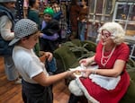 Lucy, 10, gets a second helping of Sandra Claus' signature chocolate chip cookies at the Magical Markets of Merriment in Bend, Dec. 7, 2024.