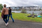 FILE - Pedestrians walk along the Vera Katz Eastbank Esplanade in Portland, March 26, 2024, past a dismantled campsite. Portland Mayor Ted Wheeler is attempting to restrict camping on public property.