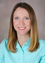 Dr. Amy Hermesch, of Oregon Health and Science University. Headshot of smiling woman with light brown hair wearing a turquoise button up shirt.