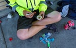 A man, 23, sits on the sidewalk in downtown Portland, preparing what he says is heroin, June 25, 2021. 