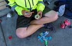 A man, 23, sits on the sidewalk in downtown Portland, preparing what he says is heroin, June 25, 2021.