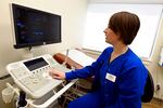A nurse demonstrates an ultrasound machine.