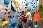 Portland-based nonprofit Ukandu's The Loft is a 21,000-square-foot community center for children with cancer and their families, located in Portland's Lair Neighborhood that opens on Oct. 21, 2026. A mother is shown helping her son ascend a two-story climbing wall inside The Loft in this undated, provided photo.