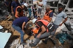 Palestinians search for survivors after an Israeli airstrike on a residential building in Nuseirat Refugee Camp, Gaza Strip, Sunday, May 19, 2024.