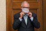 Washington Gov. Jay Inslee puts on a mask after speaking at a news conference, Wednesday, Aug. 18, 2021, at the Capitol in Olympia, Wash.