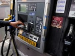 A woman presses a button to fill up a gas tank at a gas station in East Dundee, Ill. on March 19.