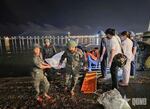 This image from a video provided by QDND shows a body being carried on stretcher after a tourist boat capsized in Ha Long Bay, Vietnam on Saturday, July 19, 2025. (QDND via AP)