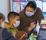 Reyes, 11, left, works with teacher Jasmine Lowe in class. 