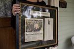 Runge holds a framed newspaper article about returning to UO for the closing of McArthur court.