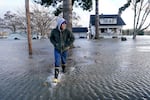 Benjamin Lopez steps from floodwater surrounding his parents home Monday, Nov. 15, 2021, in Sedro-Woolley, Wash. The heavy rainfall of recent days brought major flooding of the Skagit River.