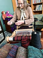 Fiber artist Janis Johnson of Portland demonstrates weaving one of her warm wool and silk scarves on a simple rigid heddle loom at Fiber Rhythm Craft & Design during the 2018 Rose City Yarn Crawl. She also sells her cotton dish towels and other items in the shop, located in the Ford Building on inner Southeast Division Street.