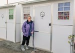 Kathryn Perkins poses outside a tiny home she lives in at a non-congregate homeless shelter located in The Dalles on Dec. 13, 2022. Perkins, who is currently experiencing homelessness, has lived at the shelter for six months with her dog, Monster, while trying to transition to permanent housing.