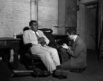 Saxophone great Charlie Parker being interviewed backstage at the Civic Auditorium, circa 1954.