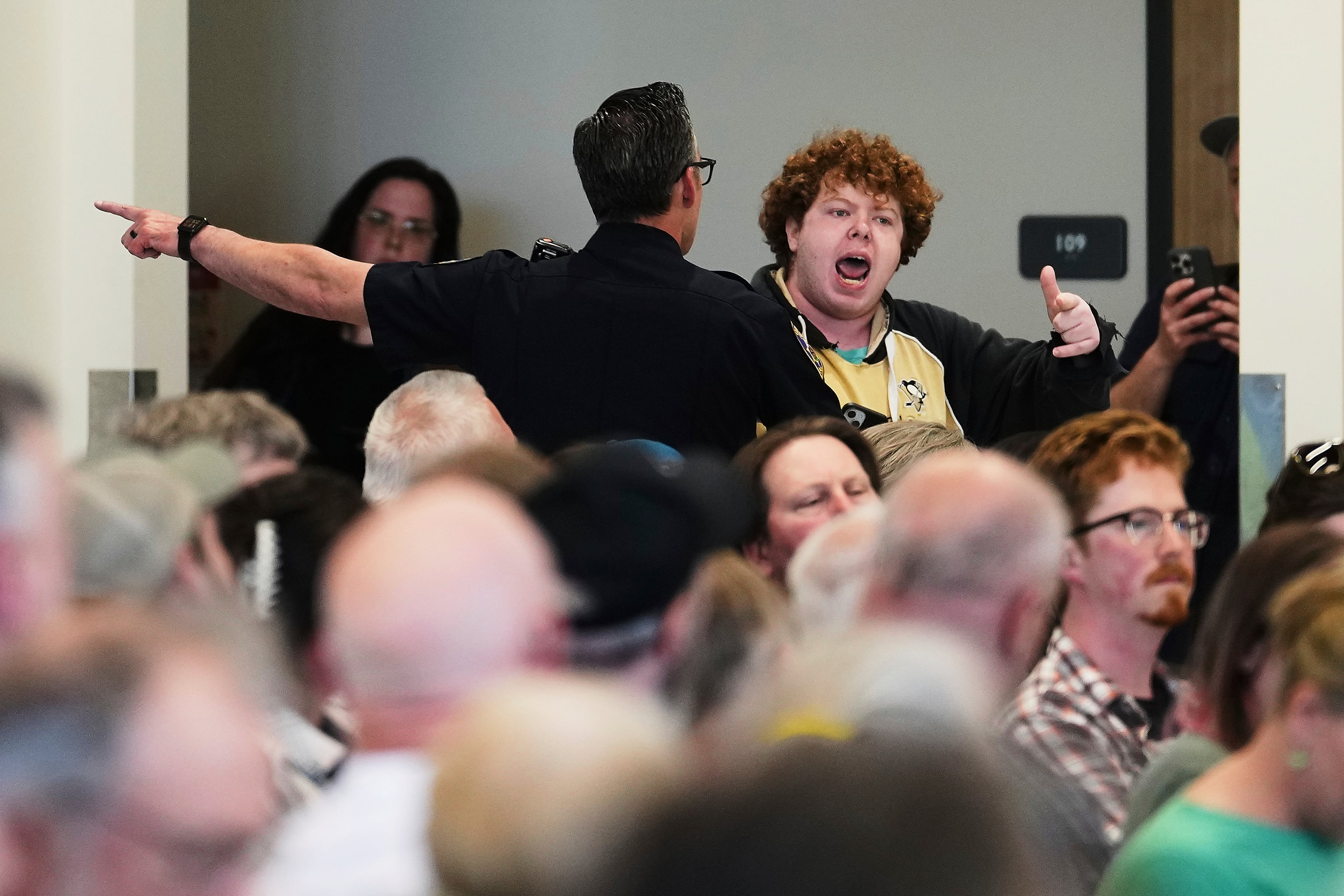 A protester is pulled away from the crowd and arrested during the town hall event.