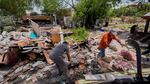 Homeowner Daniel Olivas, right, clears debris from his home that was heavily damaged from flash floods along the Guadalupe River in Kerrville, Texas, on Thursday, July 10, 2025.
