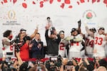 Ohio State head coach Ryan Day celebrates with the trophy alongside his team after winning the Rose Bowl College Football Playoff against Oregon, Wednesday, Jan. 1, 2025, in Pasadena, Calif.