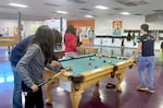 Young people play pool at the Blazer Boys & Girls Club in Northeast Portland. Along with the Urban League of Portland and REAP, the organization is hosting programming during school hours for students attending neighborhood schools affected by the Portland teachers strike.
