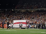 Fans watch as Buffalo Bills football player Damar Hamlin leaves Cincinnati's Paycor Stadium in an ambulance on Monday night after experiencing a cardiac arrest during a game.