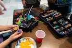 Hailey Fisher explains why she chose the specific Beyblades, and their set ups, that she’s using for the tournament out of all of her other Beyblades and parts at the final Beyblade tournament being held at the Lloyd Center shopping mall in Portland, Ore., on Aug 2, 2026. The tournaments will be moved to Gambit’s Games and BatCave Games after the Lloyd Center closes.