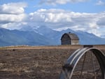 A barn near Pablo, Montana with the Mission Mountains in the distance. Western Montana is experiencing more frequent heat waves, and officials are concerned about health impacts on isolated rural residents.